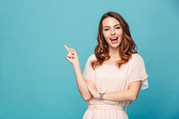 Young woman smiling and pointing behind her