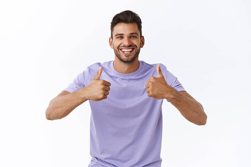 Young man smiling with thumbs up