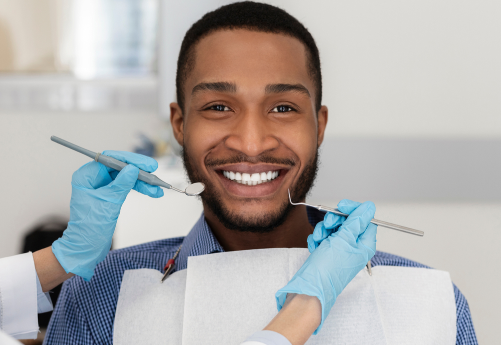 dentist examining man's smile with dental tools
